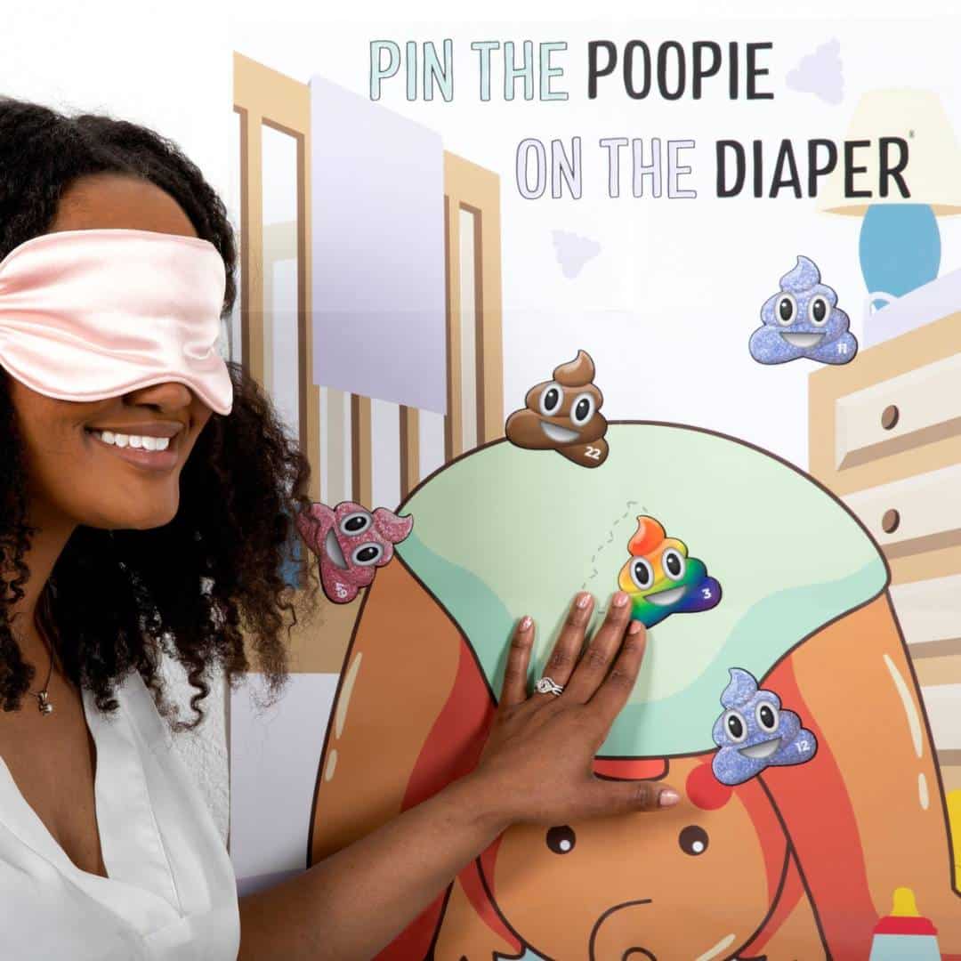 woman playing pin the poopie on the diaper baby shower game