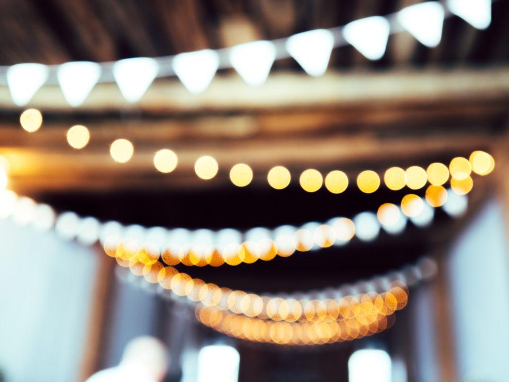 rows of bunting and fairy lights out of focus in a barn setting