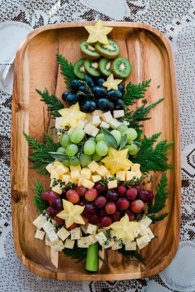 a tree shaped christmas cheeseboard on a lace background