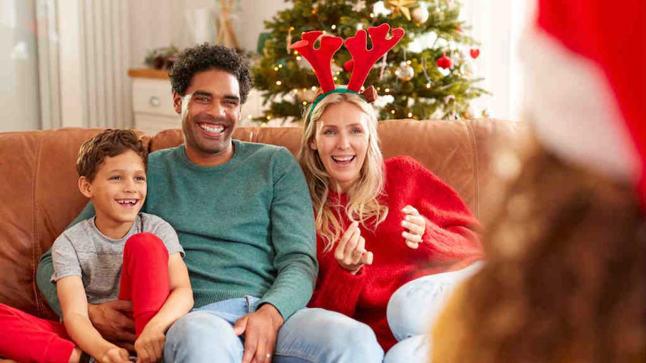 a family smiling at young girl wearing santa hat