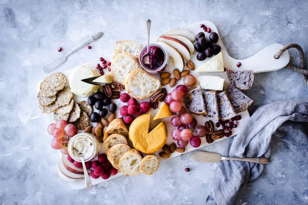 a vegan christmas cheeseboard with nuts, cranberries and vegan cheese