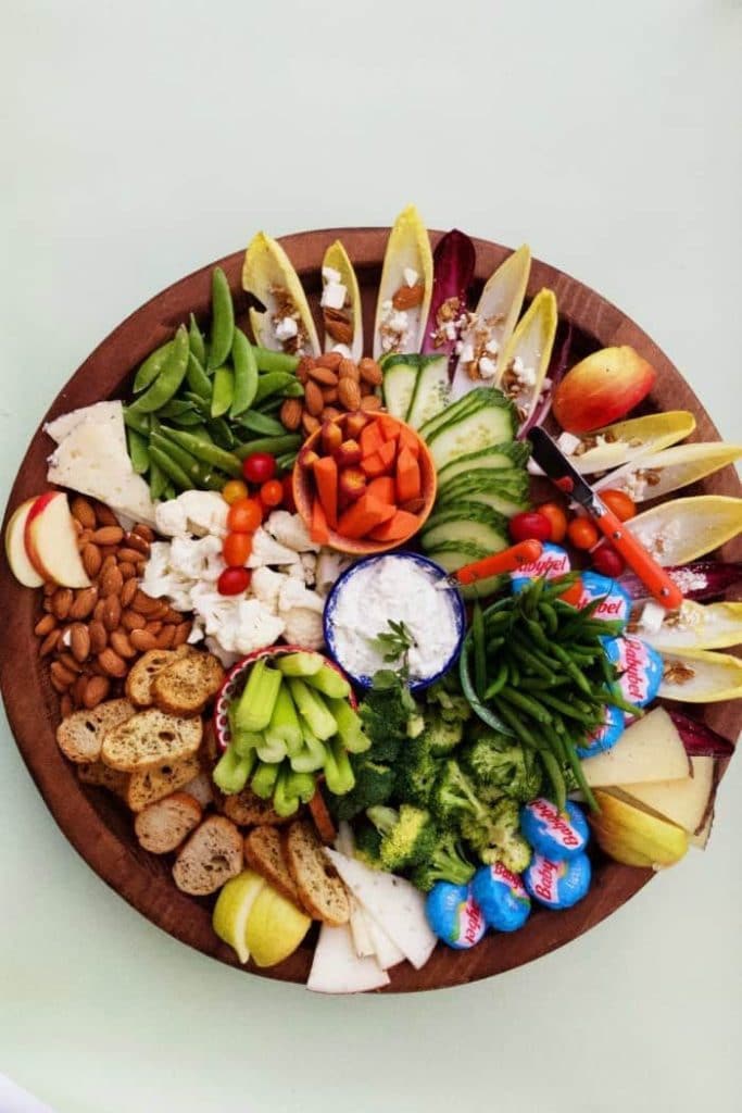 a healthy christmas cheeseboard with vegetables, nuts and cheese