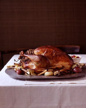 a roast turkey on a platter of vegetables