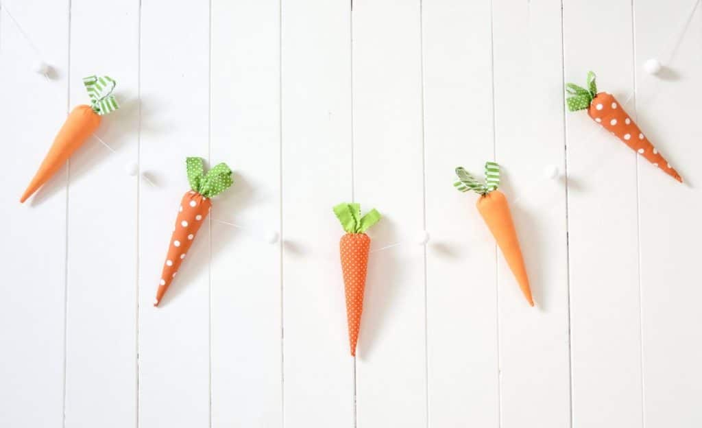 carrot bunting on white wooden wall background