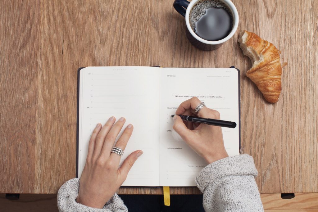 flatlay of a person writing in a journal