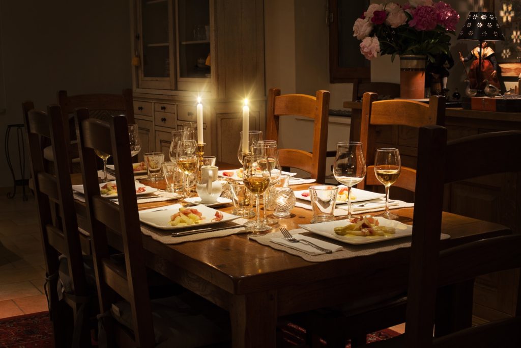 a dinner table setting at night with candles lit