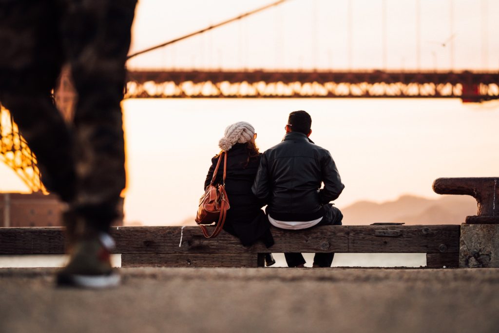 two people sitting look at a bridge deep conversation starters