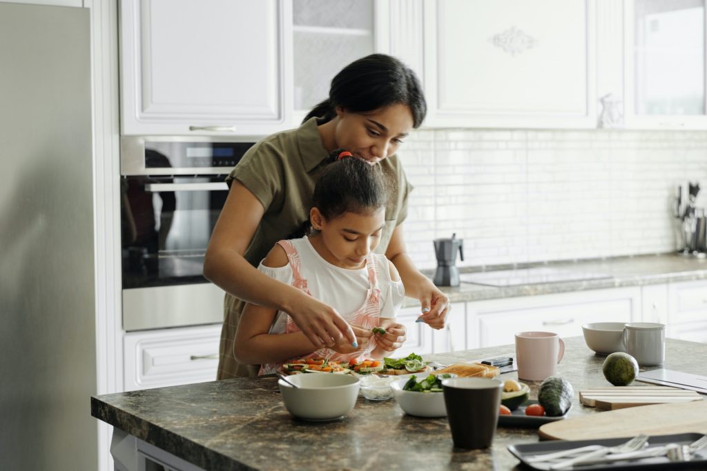 a person helping a child prepare food