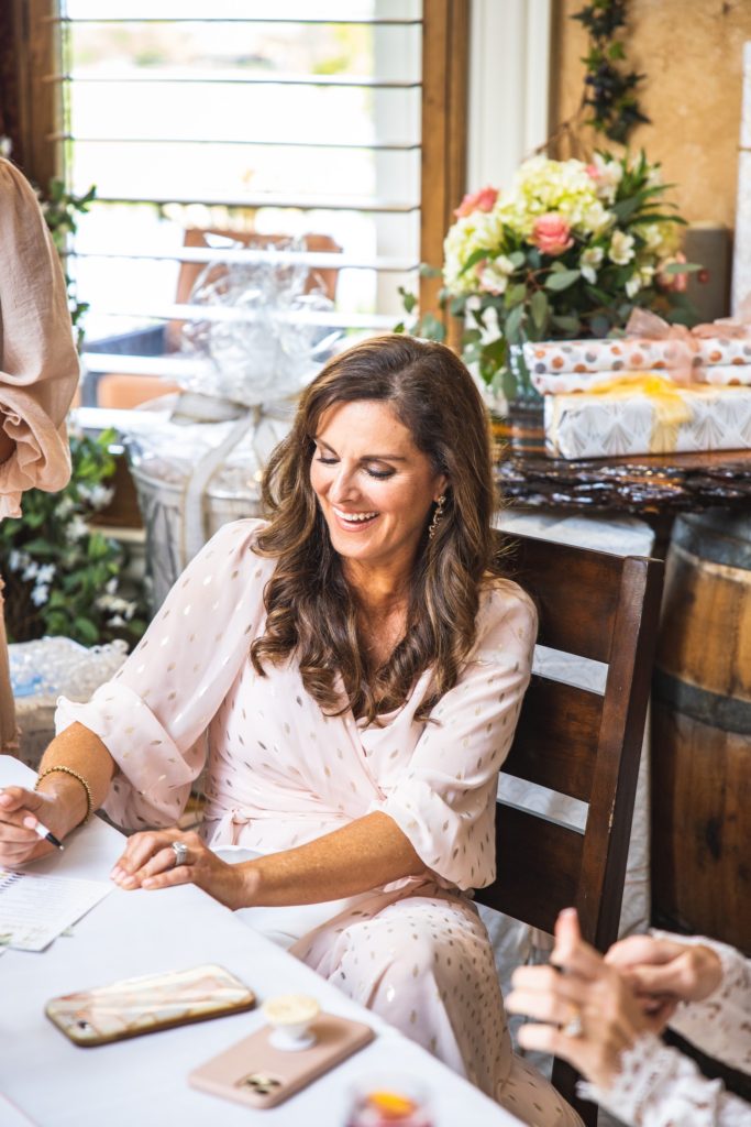 a woman smiling down at her notes