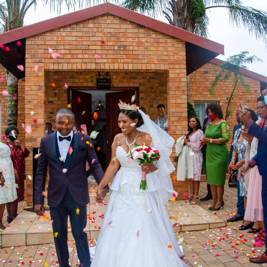 married couple at their wedding event with guests