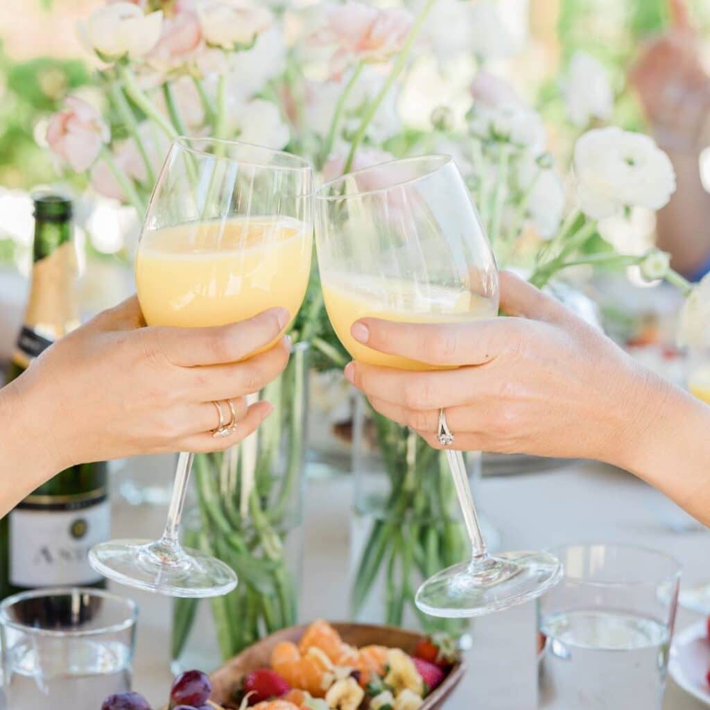 cheersing mimosas at a sunday brunch party